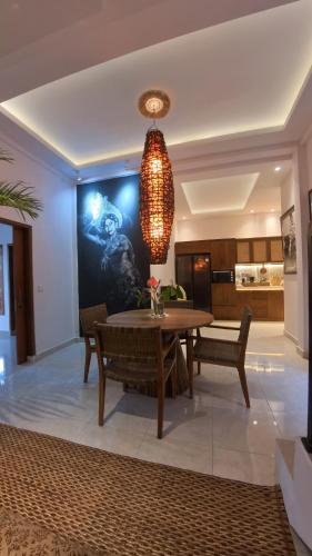 a dining room with a table and a chandelier at Villa SARY AKAR in Payangan