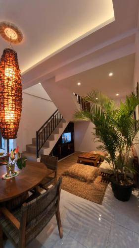 a living room with a table and a staircase at Villa SARY AKAR in Payangan