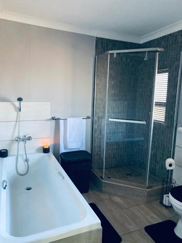 a bathroom with a tub and a shower and a toilet at 23 On Jupiter in Polokwane