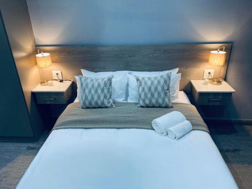 a bedroom with a large bed with two night stands at 23 On Jupiter in Polokwane