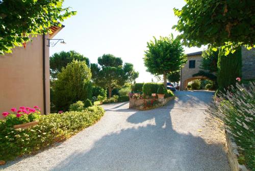 a road with flowers and a building and trees at Il Rondò Boutique Hotel in Montepulciano