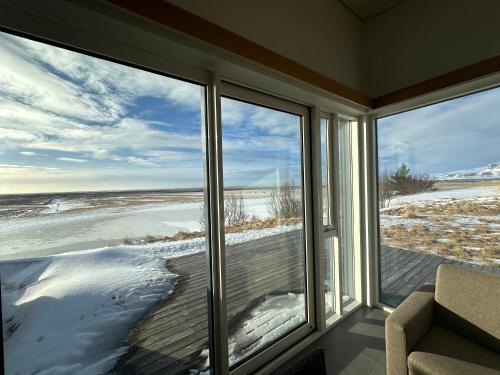 a screened in porch with a view of the beach at Eiðhús Apartments in Vegamót