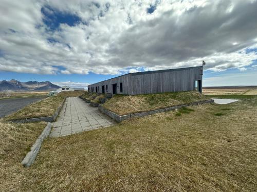 a building in the middle of a field at Eiðhús Apartments in Vegamót