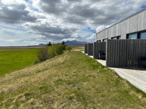 a building on a hill next to a field at Eiðhús Apartments in Vegamót