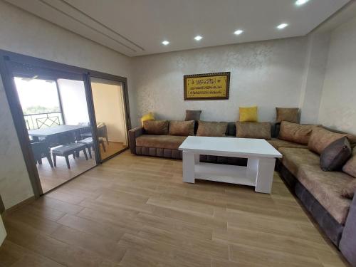 a living room with a couch and a table at Fenêtre sur le paradis in Saidia 