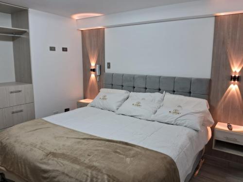 a bedroom with a large bed with white pillows at Hotel El Virrey Suite in Espinar