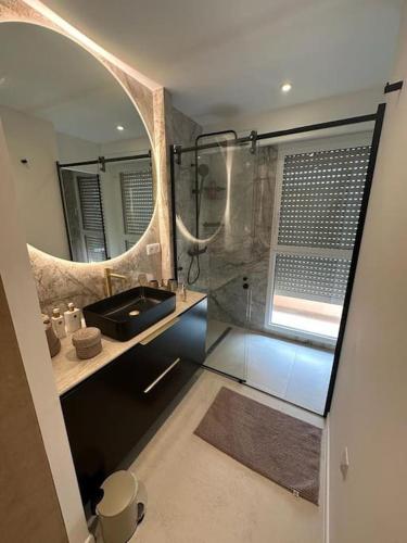 une salle de bain avec un lavabo et une douche avec un miroir dans l'établissement Appartement 4 pièces de luxe à Juan-les-Pins, à Antibes