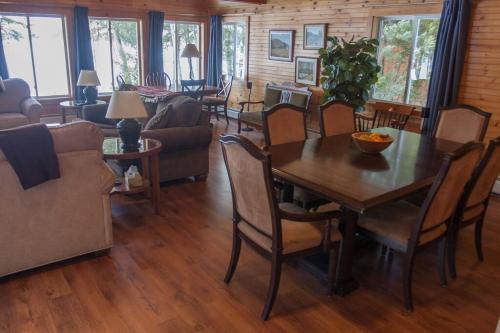 a living room with a wooden table and chairs at Lakefront cottage on East Pond in Oakland