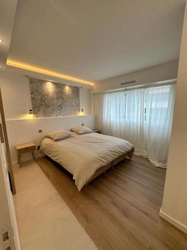 une chambre avec un grand lit et une fenêtre dans l'établissement Appartement 4 pièces de luxe à Juan-les-Pins, à Antibes