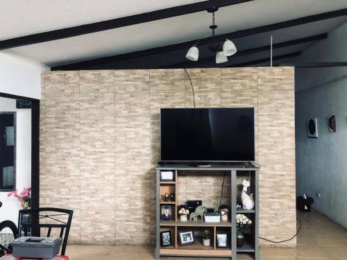 a living room with a television on a brick wall at Casa Mandala in Arenilla