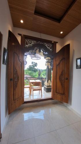 an open door to a patio with a table in the background at Villa SARY AKAR in Payangan