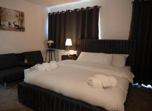 a bedroom with a large bed and a couch at Digbeth Aparthotel in Birmingham