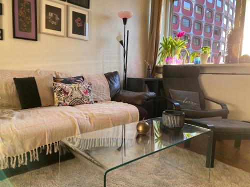 un salon avec un canapé et une table en verre dans l'établissement Tour Reflet Paris 15, A cozy and welcoming home, just like your own, à Paris