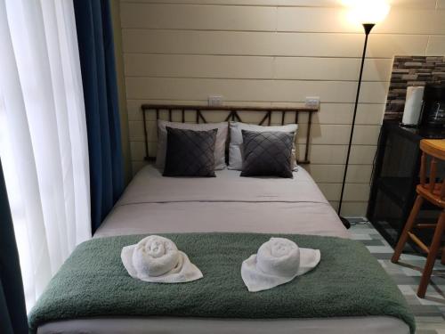 two towels on a bed with a green blanket at Kahel in Fortuna