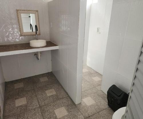 a white bathroom with a sink and a mirror at Pousada Marajoara- Hotel Fazenda-Turismo de Aventura in Soure