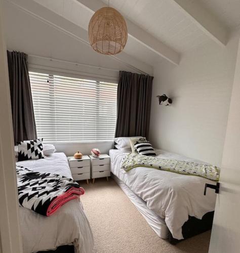 a bedroom with two beds and a window at The Lake Haus in Mangakino