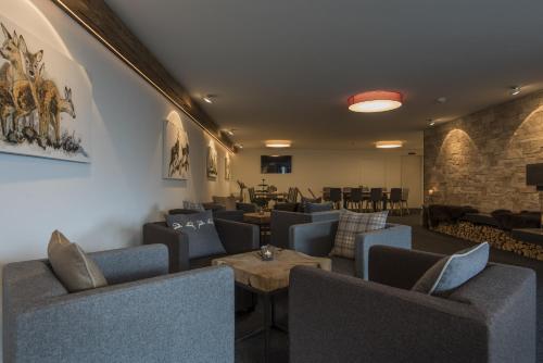 a waiting room with couches and tables at Berghotel Tgantieni in Lenzerheide