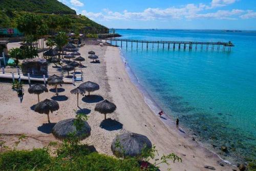 een strand met stoelen en parasols en een pier bij Comodo apt Cerca del Malecon 5 min caminando in La Paz