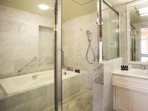 a bathroom with a shower and a tub and a sink at SHIROYAMA HOTEL kagoshima in Kagoshima
