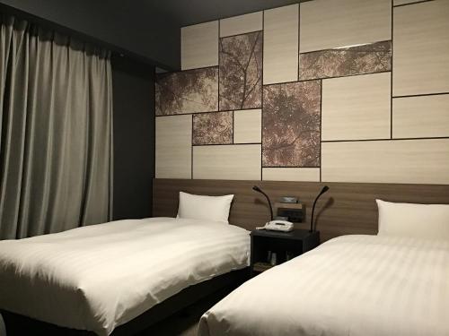 - 2 lits dans une chambre d'hôtel avec des draps blancs dans l'établissement Hotel Route Inn Kounosu, à Kōnosu