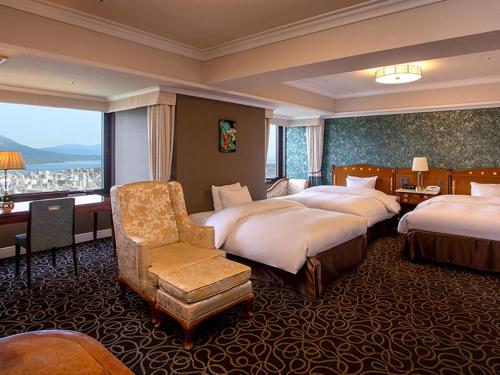 a hotel room with two beds and a desk at SHIROYAMA HOTEL kagoshima in Kagoshima
