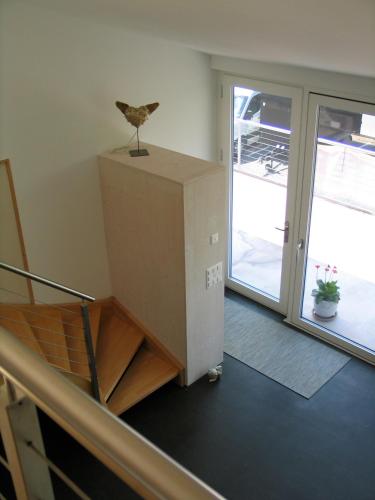 a staircase in a building with a bird on top of a box at Artist's Loft zur Maloya in Ormalingen