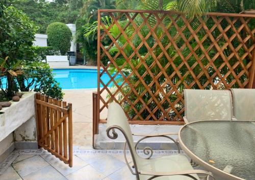 a fence with a table and chairs next to a pool at Hermosa casa frente a la playa in Same