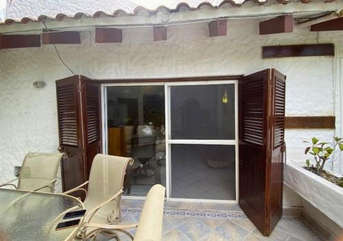 a patio with chairs and a sliding glass door at Hermosa casa frente a la playa in Same