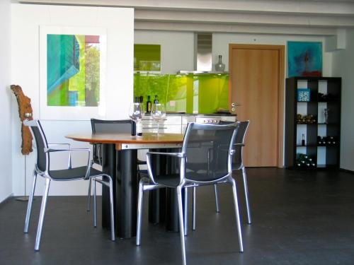 een eetkamer met een tafel en stoelen bij Artist's Loft zur Maloya in Ormalingen