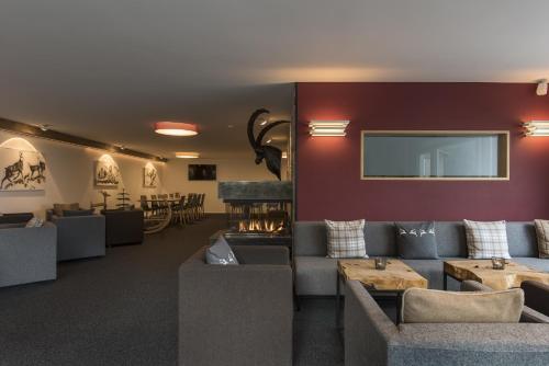 a living room with couches and a tv at Berghotel Tgantieni in Lenzerheide