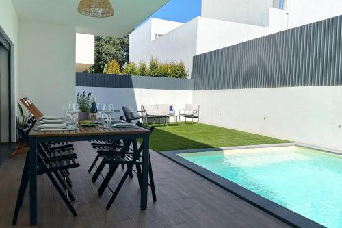 a dining table and chairs next to a swimming pool at Villa Verde Priv Pool, 10min beach, near Lisbon in Amora