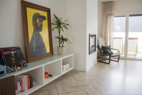 a living room with a painting of a man at Villa Verde Priv Pool, 10min beach, near Lisbon in Amora