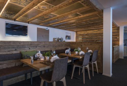 a restaurant with wooden walls and wooden tables and chairs at Berghotel Tgantieni in Lenzerheide