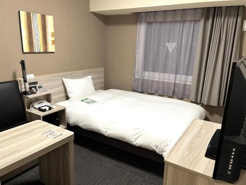 a hotel room with two beds and a television at Hotel Route Inn Takamatsu Yashima in Takamatsu