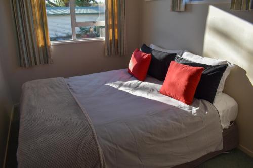 a bedroom with a bed with four pillows on it at Route79 Holiday Park Geraldine in Geraldine