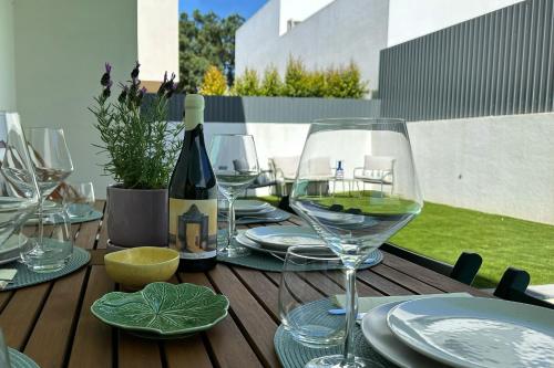 a table with wine glasses and a bottle of wine at Villa Verde Priv Pool, 10min beach, near Lisbon in Amora