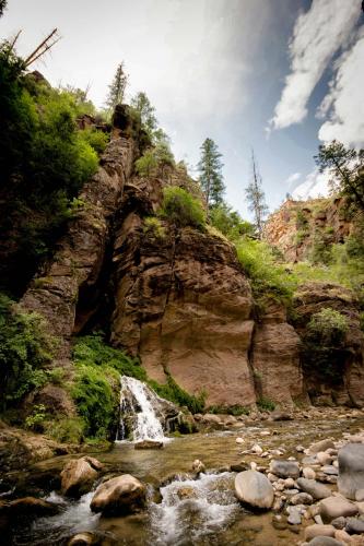 a waterfall on the side of a rocky mountain at Beehive Basecamp Explore Ski Play and Make Memories in Parowan
