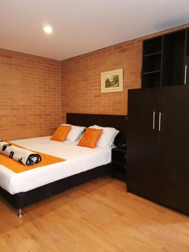 a bedroom with two beds and a brick wall at Hotel HK Kozy SAS in Bogotá
