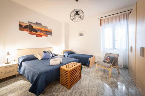 a bedroom with a blue bed and a chair at Tramonto D'oro in Gallipoli