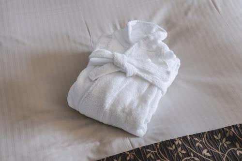 a white towel sitting on top of a bed at Kurashiki Royal Art Hotel in Kurashiki