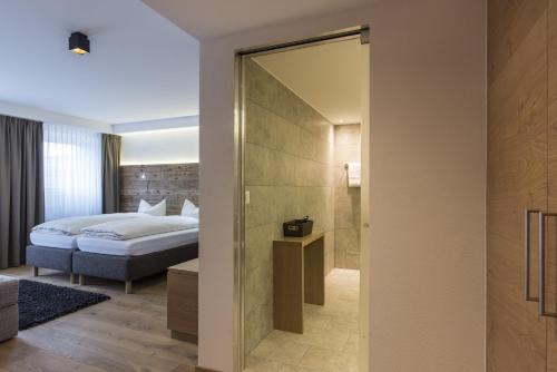 a hotel room with a bed and a shower at Berghotel Tgantieni in Lenzerheide
