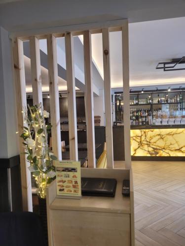 a restaurant with a bar and a counter with a vase at The Gatwick White House Hotel in Horley