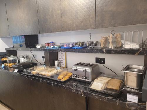 a kitchen with a counter with some food on it at The Gatwick White House Hotel in Horley