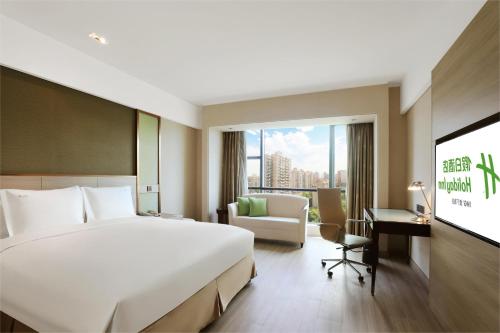 a hotel room with a large bed and a tv at Holiday Inn Shanghai Pudong Nanpu by IHG in Shanghai