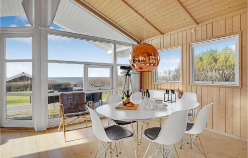 a dining room with a white table and chairs and windows at 4 Bedroom Beautiful Home In Slagelse in Slagelse