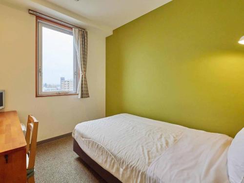 a green bedroom with a bed and a window at Kumagaya - Hotel - Vacation STAY 88845 in Kumagaya