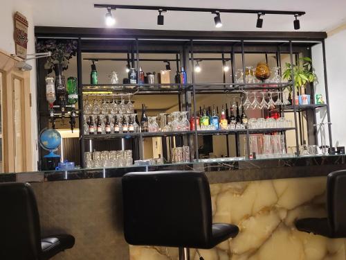 a bar with a counter with glasses on it at The Gatwick White House Hotel in Horley