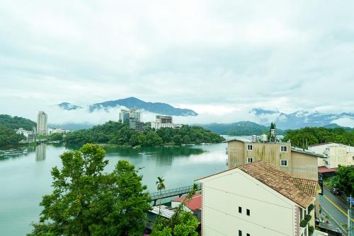 a view of a river with a city and mountains at Zhaohong homestay in Yuchi