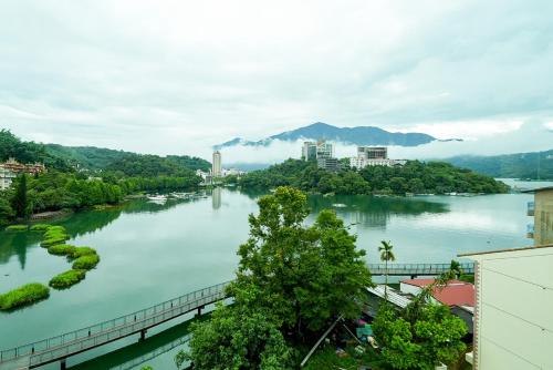 a view of a river with buildings and trees at Zhaohong homestay in Yuchi