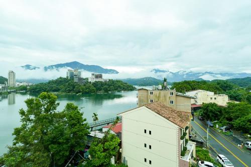 a view of a river with a city and mountains at Zhaohong homestay in Yuchi